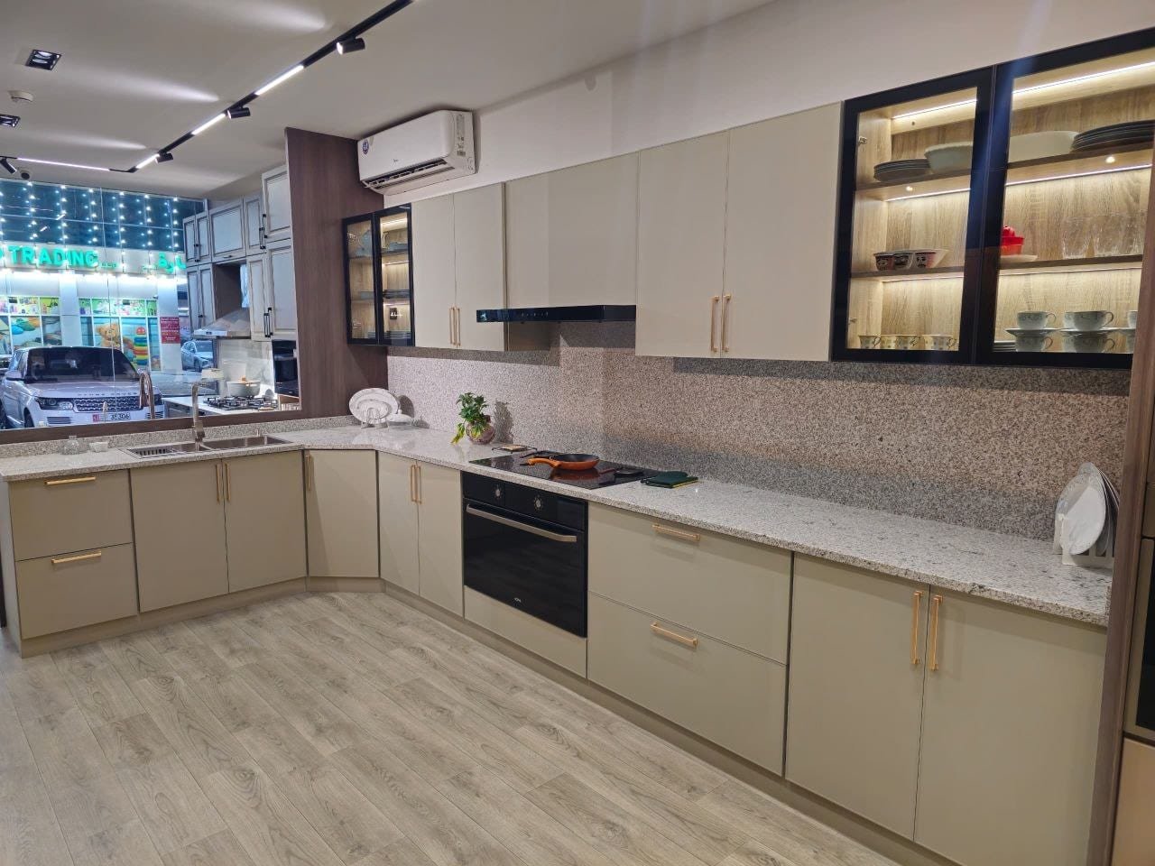 Modern aluminum kitchen with light cabinets, granite counters and glass display units